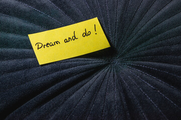 Bright yellow note with inspiring message on textured black background