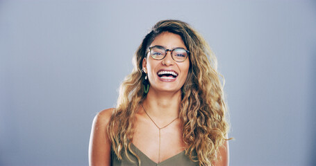 Portrait, glasses and woman laugh in studio for funny joke, comedy or joy isolated on gray background with space. Face, LOL or female person with humor, excited or happy with comic emotion in Brazil
