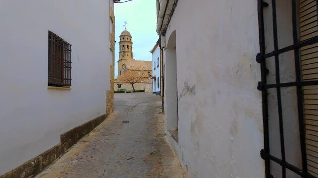 Tower of the cathedral of Baeza coming out among the old stone houses in the community of Andalusia.