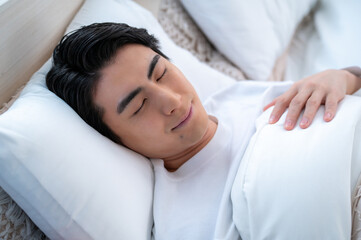 ベッドで眠る日本人男性