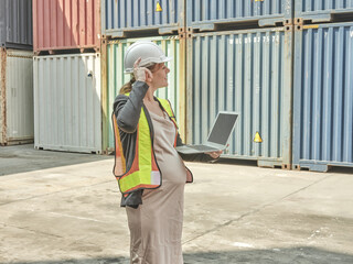 A construction worker wearing a safety vest and hardhat, standin
