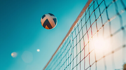 A bright volleyball soars into the air above the net in the midst of an exciting game illuminated by warm sun rays on a sandy court