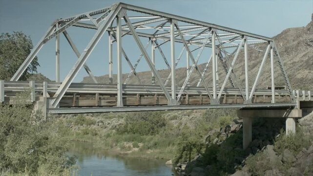 Man on One Wheel Rides Accross Junction Bridge in Taos high angle back