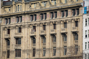 Historic European Building Facade with Ornate Balconies, Symmetrical Design, and Vintage Architectural Details in an Urban Cityscape
