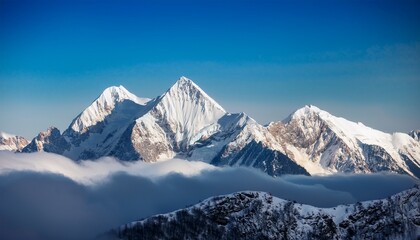 snow capped mountain peaks rise above the clouds
