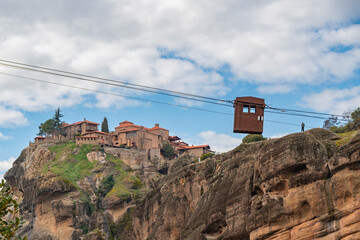 Meteora landscape with Holy trinity monastery and cable car on top of giant natural pillars, Kalabaka, Greece