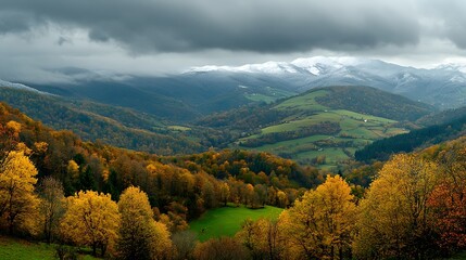 Fototapeta premium Colorful autumn landscape in a valley with snow covered mountains in the distance