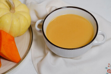 vegetable, vegan soup with cauliflower, carrot, pumpkin on white background with kitchen  textile table napkin, fresh cut vegetables