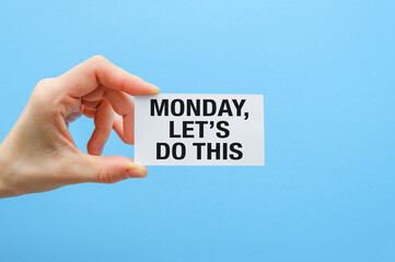 A hand holding a card that says Monday, let's do this.