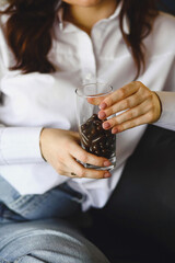 Woman holds a glass full of  vitamin pill capsules. The concept of healthy life and care. Supplements