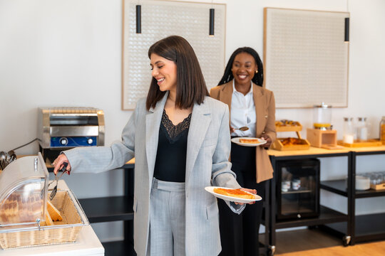 Businesswomen enjoying breakfast at hotel buffet during business trip
