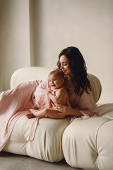 Love of a mother and baby. Mum and baby. Photoshooting in the studio of mother and daughter. Family love and care. Womans day