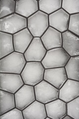 A close-up shot of a gray silicone ice mold with irregularly shaped ice cubes, showcasing a unique...