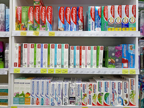 Variety of toothpaste brands on store shelves with colgate oral-b blend-a-med