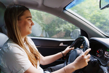 A young girl is driving a car. an inexperienced driver. 