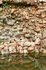 rock wall with reflection in water