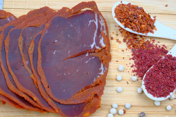 Traditional Turkish pastrami chopped with cleaver and spices (chili pepper, black pepper...) on a wooden cutting board