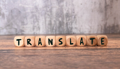 Woman making word Translate with wooden cubes at white table