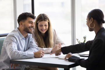 Happy couple engaged in conversation with advisor, realtor, or financial consultant, review...