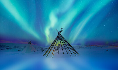 Aurora borealis (Northern lights) in the sky and many wooden snow sleds - Tromso, Norway
