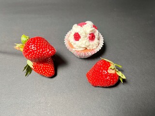 Strawberry and chocolate cupcake with cream on black background