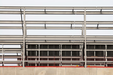 concrete building and metal beam frame during construction against grey sky