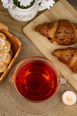 Croissants and tea on the table, view from above. Delicious aromatic breakfast