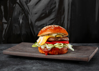 Close-up of a gourmet cheeseburger pickles on a rustic wooden board. for menu, and advertisements