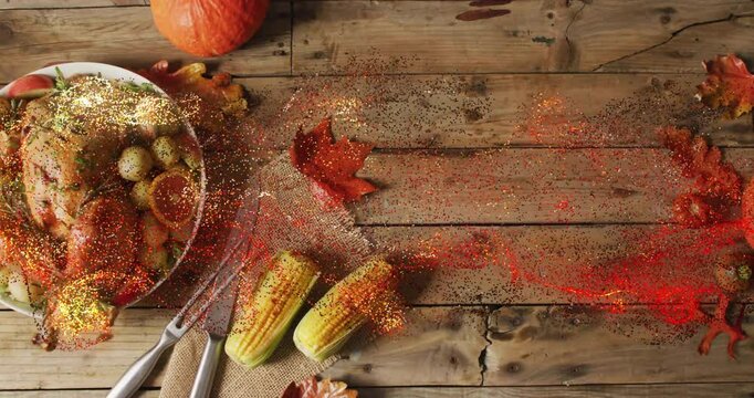 Roasted turkey on Thanksgiving dinner table with corn and autumn leaves centerpiece