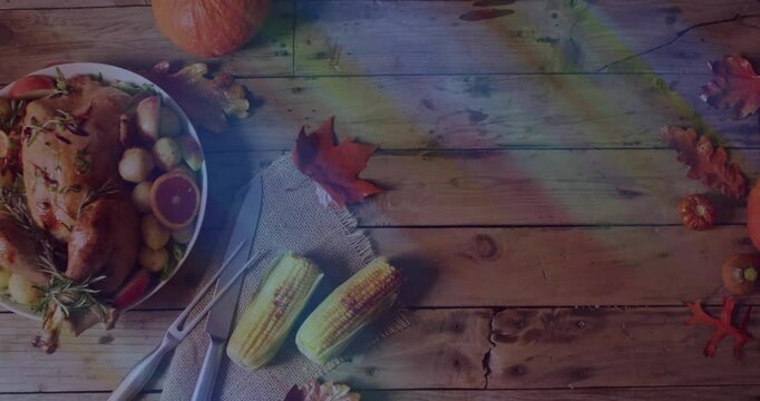 Thanksgiving table set with turkey, corn, and autumn leaves on wooden surface