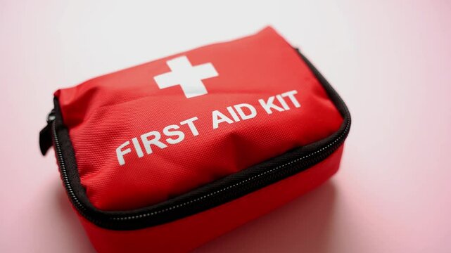 This bright red first aid kit, clearly marked with a medical cross symbol, provides easy and quick access to essential emergency supplies whether at home, while traveling, or outdoors