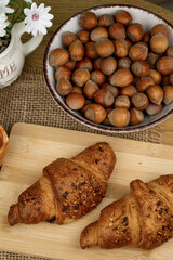 Croissants and hazelnuts on the table. Delicious healthy breakfast. Top view