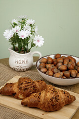 Croissants and hazelnuts on the table. Delicious healthy breakfast. Top view