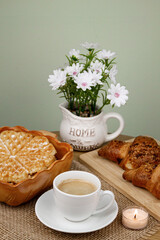 A cup of coffee, waffles and croissants on the table. Breakfast with coffee