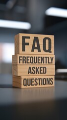 Wooden blocks stacked with "FAQ FREQUENTLY ASKED QUESTIONS" in an office setting. Represents customer support, help desk, online assistance, troubleshooting, business inquiries, and information access
