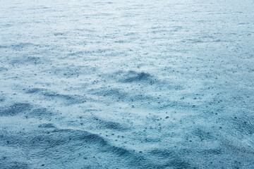 Fresh of the rain falling on the calm blue sea surface with feeling of relaxation and peace in tropical natural seasonal

