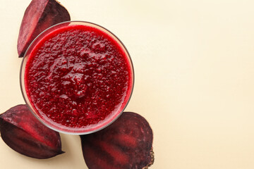 Fresh beetroot smoothie in glass and cut vegetable on beige background, flat lay. Space for text
