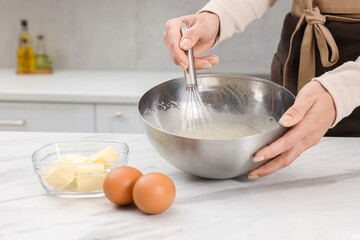 Woman making dough at white marble table indoors, closeup. Space for text