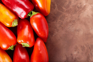 Seasonal Harvest of Bell Peppers in Flat Lay on Brown Surface for Healthy Nutrition, Copy Space
