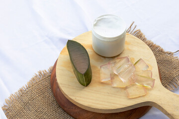 Fresh aloe vera leaves and slices arranged elegantly to highlight their soothing and hydrating...