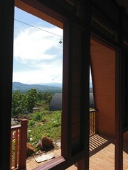 View from a wooden balcony overlooking green hills