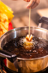 A person is cooking hot dogs in a pan