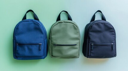 Fototapeta premium Three Colorful Backpacks Displayed on a Green Background for School or Travel