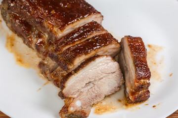 Partially sliced baked pork ribs, close-up in selective focus