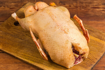 Raw gutted carcass of domestic duck on cutting board