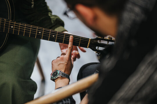 Music lesson focusing on guitar playing technique with an instructor and student