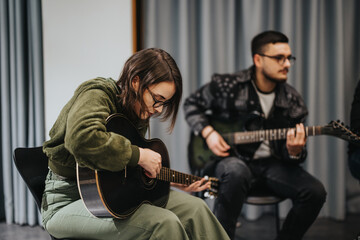 Musicians practicing in a studio, focusing on their instruments, preparing for a performance.