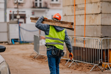 Mężczyzna nosi materiały budowlane