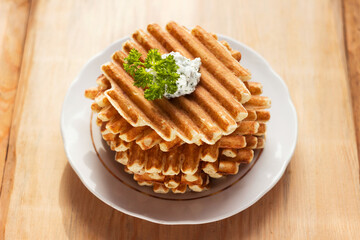 Lots of potato waffles with sauce and parsley, delicious food