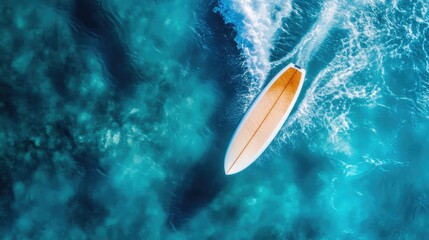Surfboard floating in crystal clear ocean waters from above